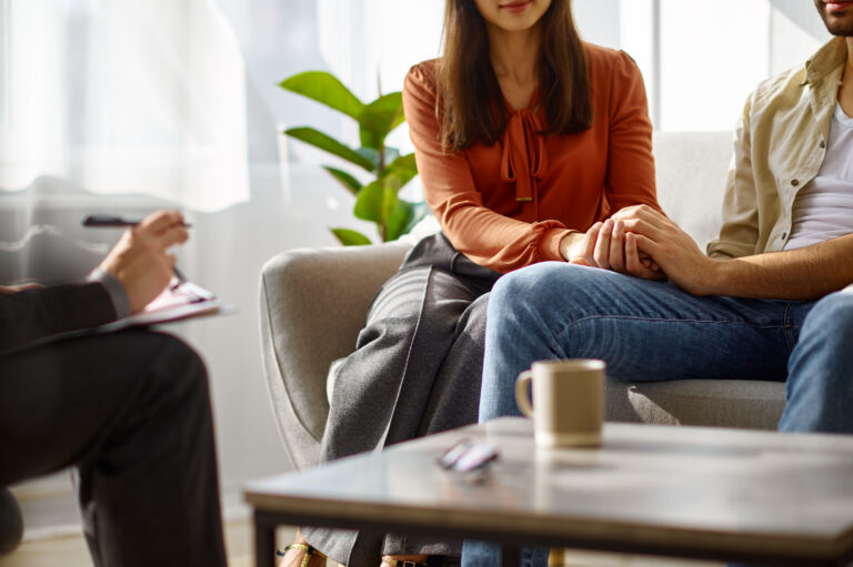 Cropped photo closeup married couple holding hands during family therapy. Psychologist counseling