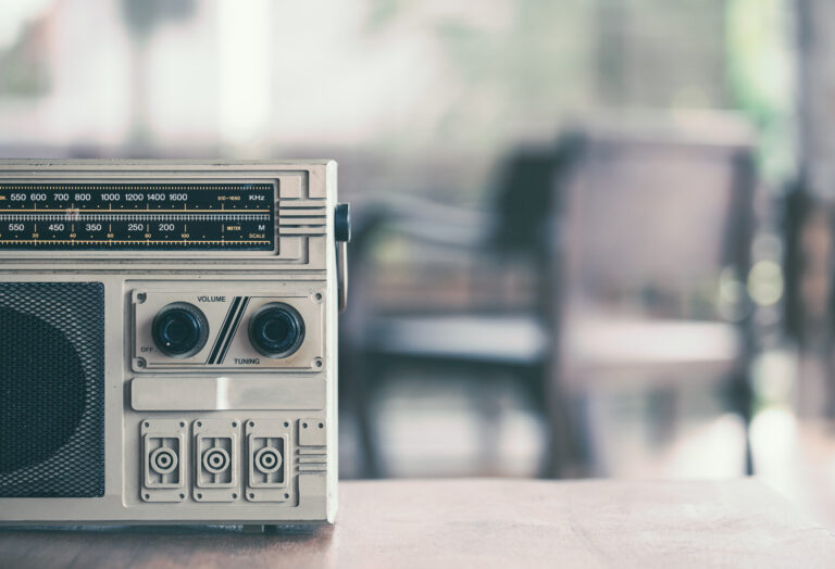 Retro radio cassette stereo on wooden table in vintage color tone