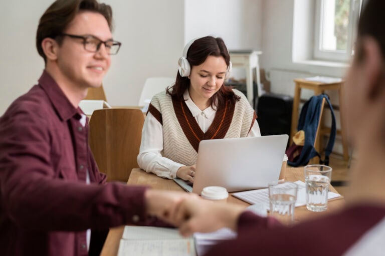 Home - Two Classmates Fist Bumping Each Other During Group Study