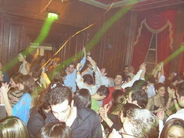 Crowd dancing under green lights in a wood panelled room at No5 Cavendish Place